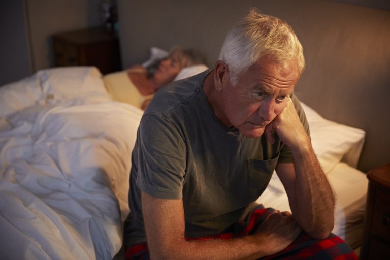 Worried Senior Man In Bed At Night Suffering With Insomnia