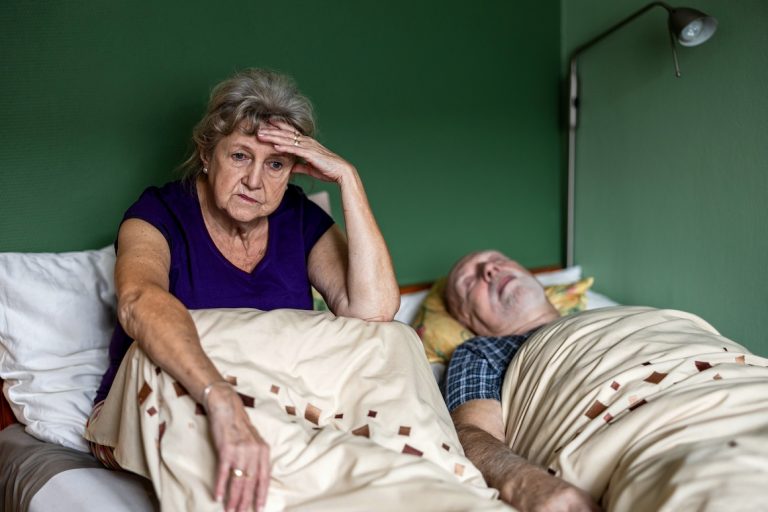 Senior woman can't sleep next to husband in bed