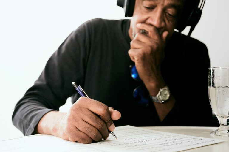 An older black musician made songs and wrote them with a ballpoint pen
