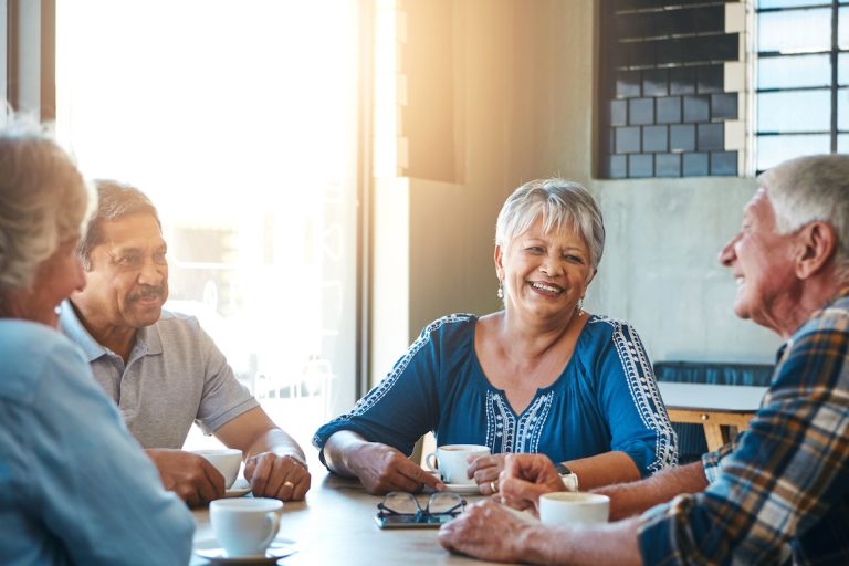 Mature, friends and group relax at coffee shop on holiday or reunion on vacation in retirement. Senior, people and talking at cafe for brunch with latte, espresso and drink cappuccino and chat.
