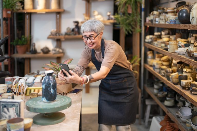 Senior woman making social media video about pottery sale online
